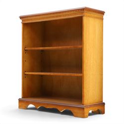 Contemporary mahogany and yew wood open bookcase, dentil cornice above two adjustable shelves, shaped apron and bracket feet 