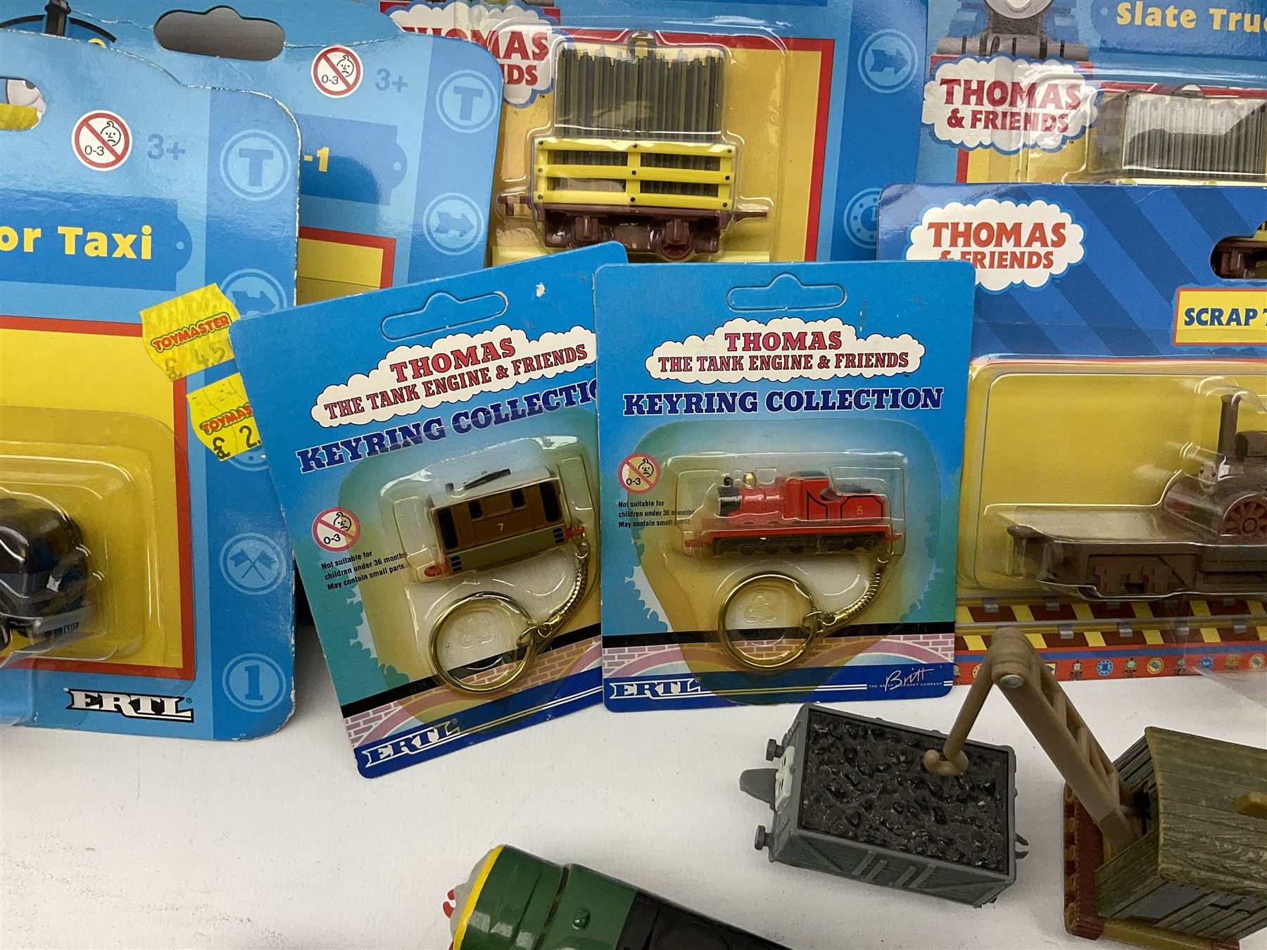 Ertl Thomas the Tank Engine and Friends die-cast models including carded Scrap Trevor, Slate Trucks, Neil, Wilbert, Sodor Taxi, Sodor Recovery Unit, Crane and four key rings; together with various uncarded models including locomotives, coal wagons, steam rollers, boat transporter, recovery units etc (over forty items)