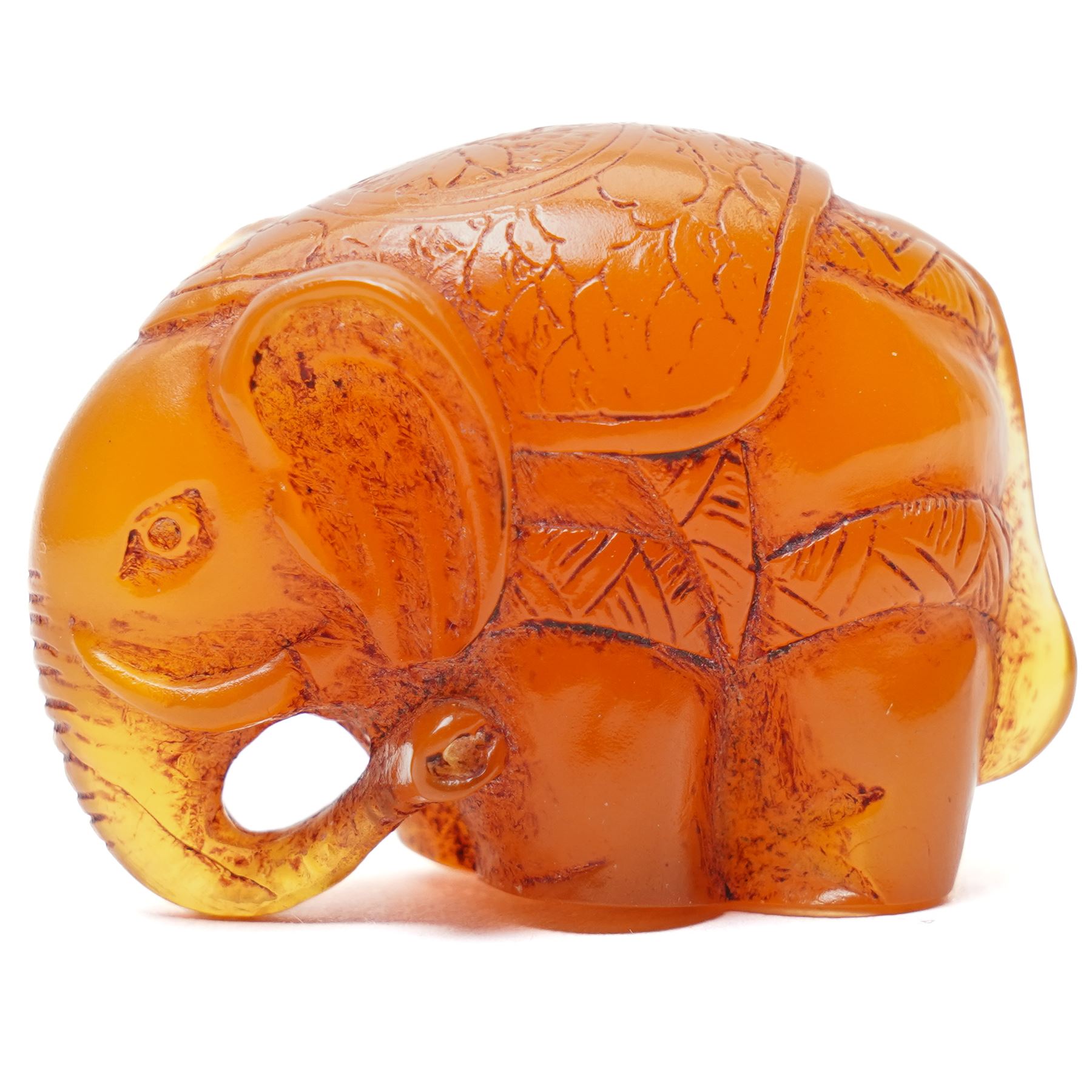 Japanese Meiji period carved amber netsuke in the form of an elephant, signed with single character mark to base, W4cm