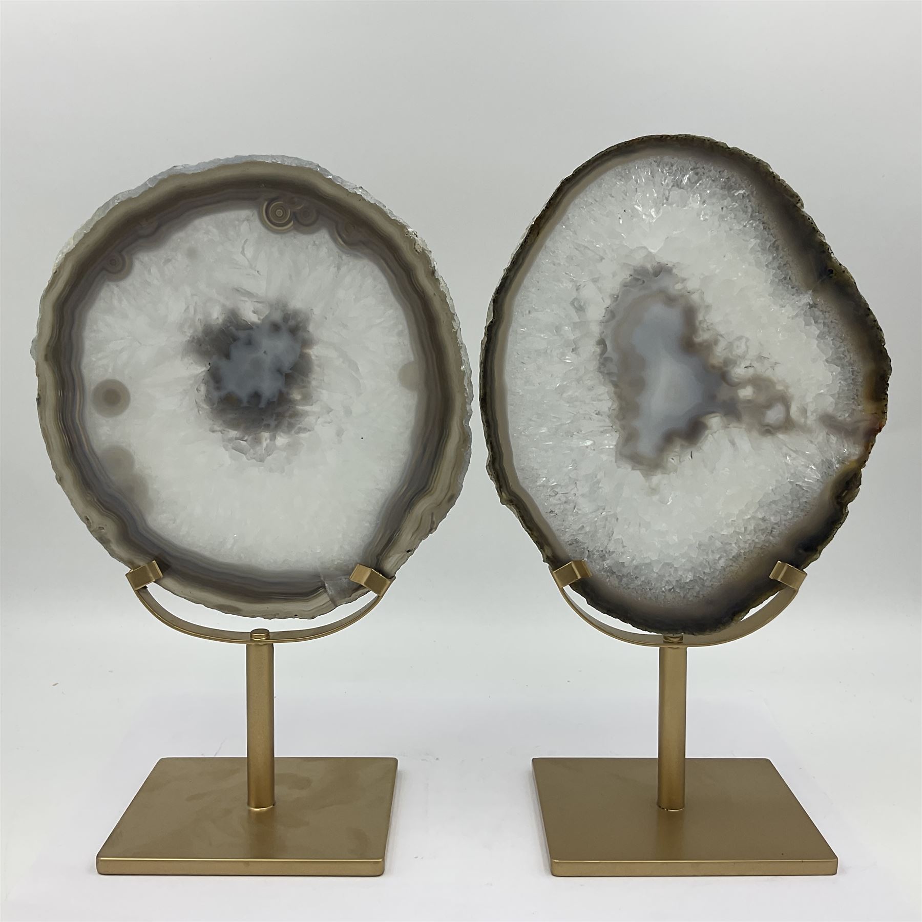 Pair of white agate slices, polished with rough edges raised upon gilt metal stands, H24cm