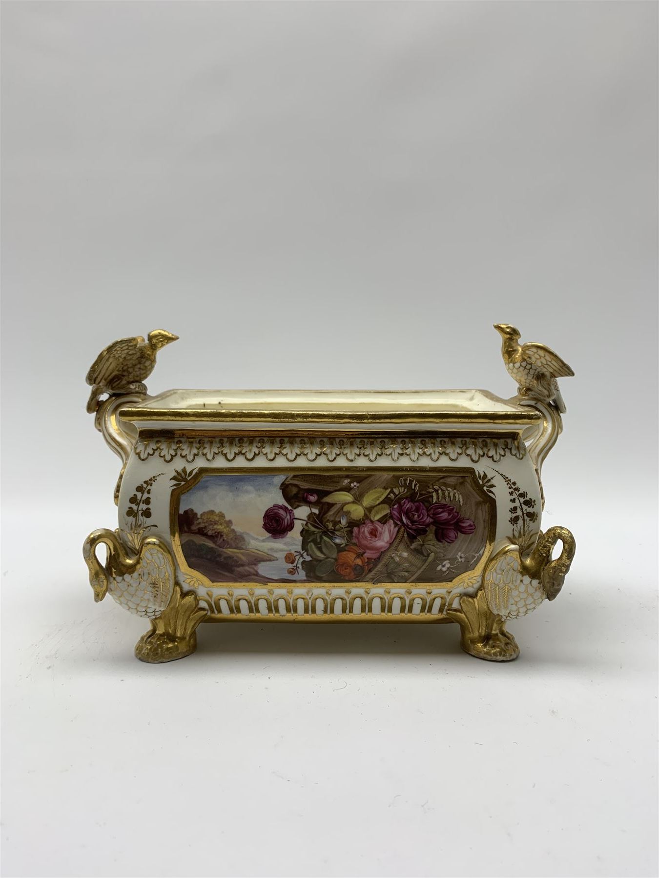 19th century Coalport bough pot, circa 1820, of bombe form, the body with twin handles surmounted by two birds and raised upon four feet modelled as swans, hand painted with two panels depicting an urn of flowers set against a mountainous landscape, the whole heightened in gilt throughout, H13cm L21cm