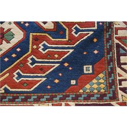 Caucasian Kazak indigo and vermillion ground rug, the geometric field boldly woven with two medallions interspersed with symbolic tribal motifs and shapes, with contrasting ivory guard band