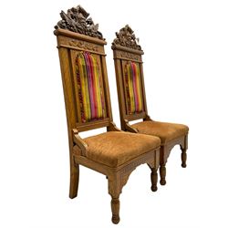 Set of six 20th century Carolean design oak high back chairs, the pediment carved with dragons and central Green Man mask with trailing foliage, the backs upholstered in striped fabric, on turned front supports