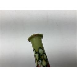 Three Minton Secessionist vases, with tube-lined stylised flower decoration, two upon a red ground and third upon a purple ground, all with printed mark to base 'Minton Ltd, No. 33', H13cm