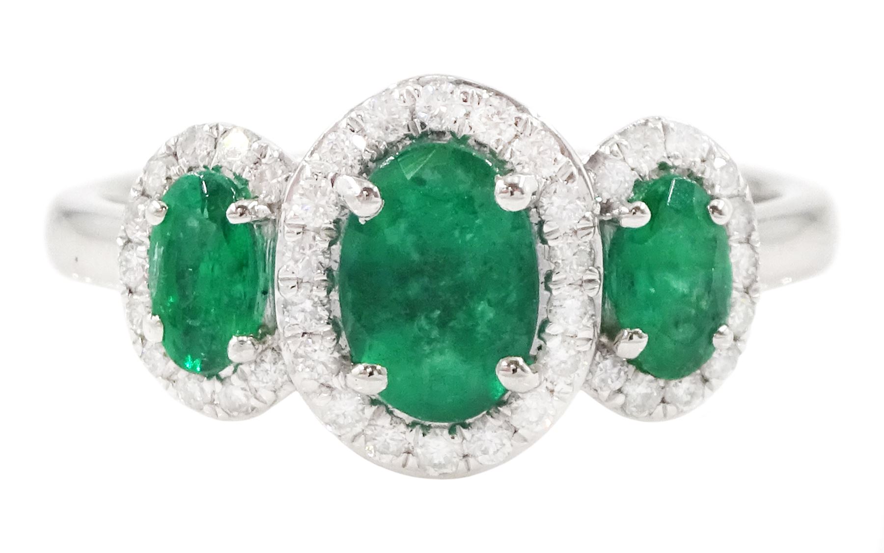 Platinum emerald and diamond trilogy ring, three oval cut emeralds surrounded by round brilliant cut diamonds, hallmarked, total emerald weight approx 1.05 carat, total diamond weight approx 0.25 carat
