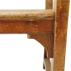 Early 20th century pine chapel bench, with moulded plank back rail over plain rail, with book storage to the back, open shaped end supports with curved arms, turned front uprights, plank seats, square legs united by low stretchers
