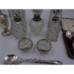 Group of silver, comprising set of six silver coffee spoons, in fitted case, six silver mounted cut glass scent bottles, pair of silver mounted cut glass open salts, and a silver handled preserve spoon, all hallmarked, together with an American silver pepper shaker on weighted foot, stamped sterling, tallest H20cm