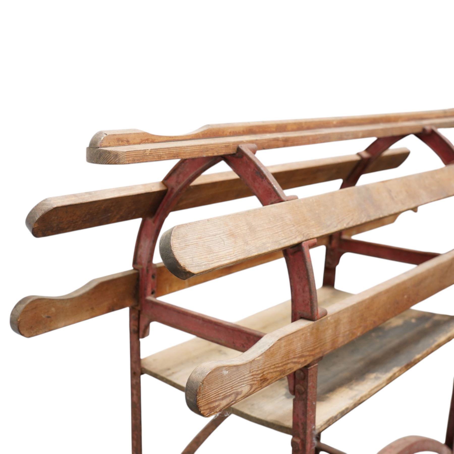 Cast iron and wooden saddle rack, arch form with shelf beneath and wheels to one end, pair of shaped handle poles