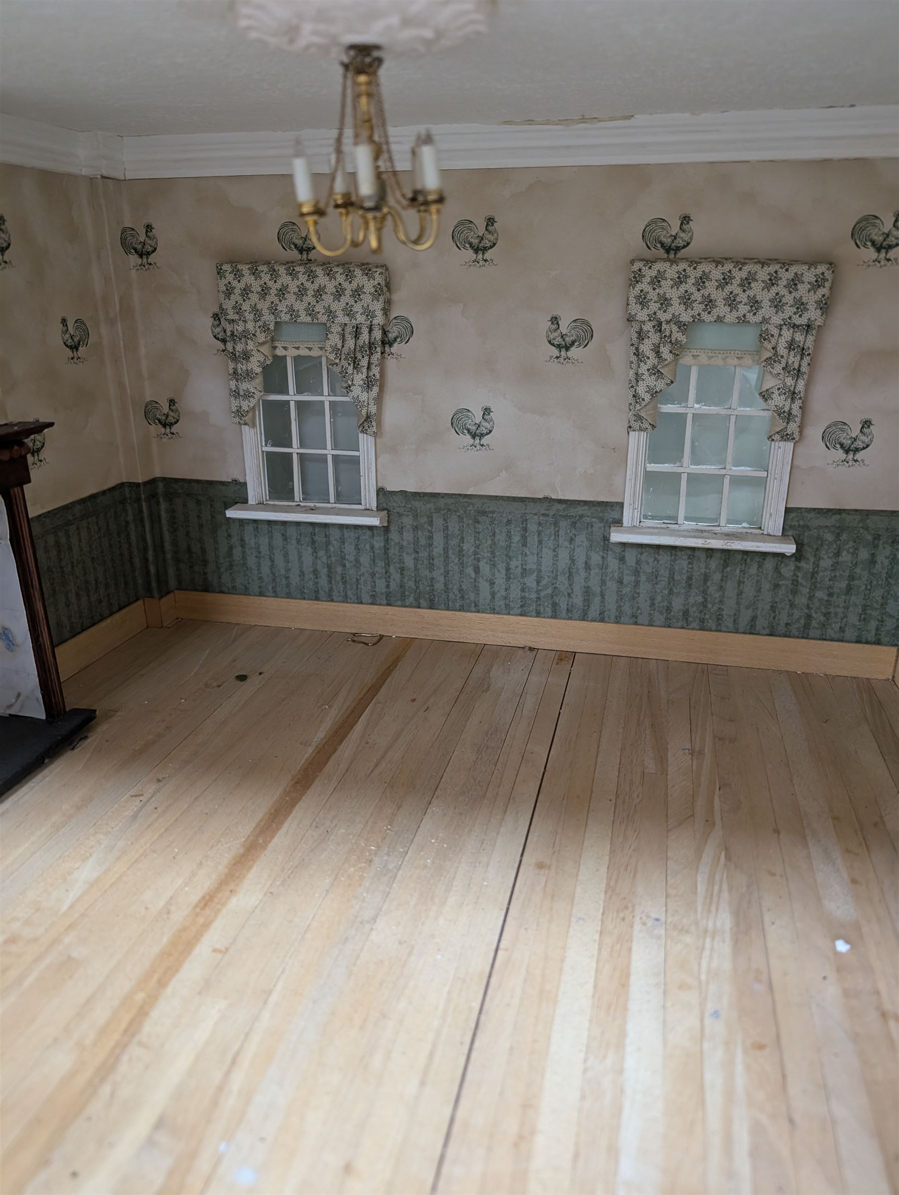 Two modern three storey dolls houses, each painted green with decorated interiors, both upon a single white wooden base, together with a large collection of dolls house furniture, accessories and figures 