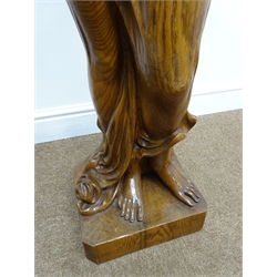  Large carved figured oak model of a diaphanously draped young woman, she stands barefoot with hands clasped above bowed head, on naturalistic square base with tree stump, H120cm, W37cm, D30cm   