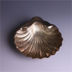 Edwardian silver butterdish in the form of a clam shell and upon four bun feet, hallmarked Williams Birmingham Ltd, Birmingham 1905, with a silver plated butter knife, contained within a fitted tooled leather case, width of dish 13cm