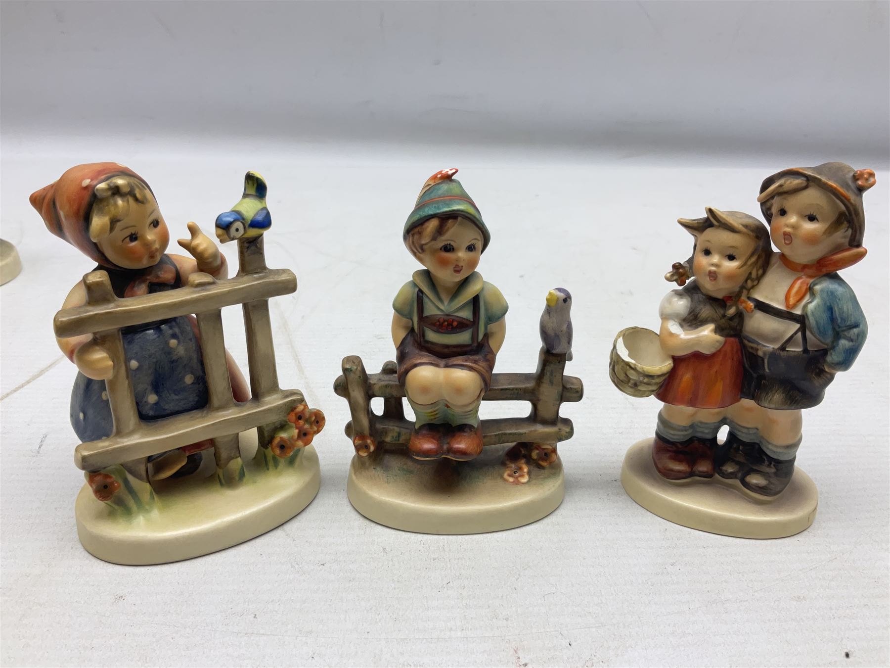 Seven Goebel Hummel figures, comprising Chimney Sweep 12/I, Apple Tree Girl 14/I, Apple Tree Boy,  Little Goat Herder 200/I, Surprise 94 3/0, Signs of Spring 203/20 and Wayside Harmony 111/30, tallest H15cm