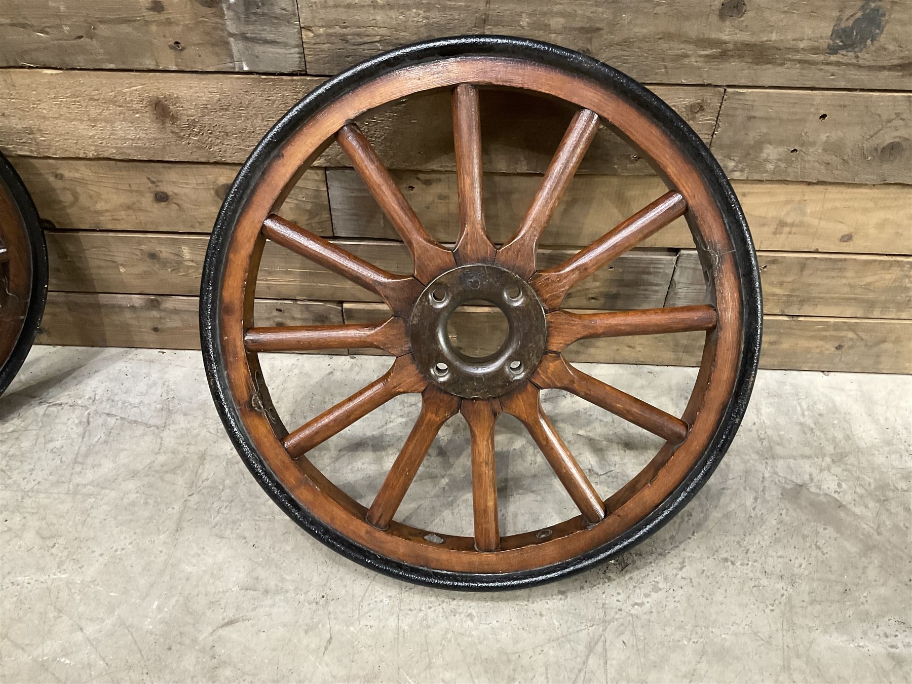 Set of four wheels from an early 20th century cart, wood with metal outer