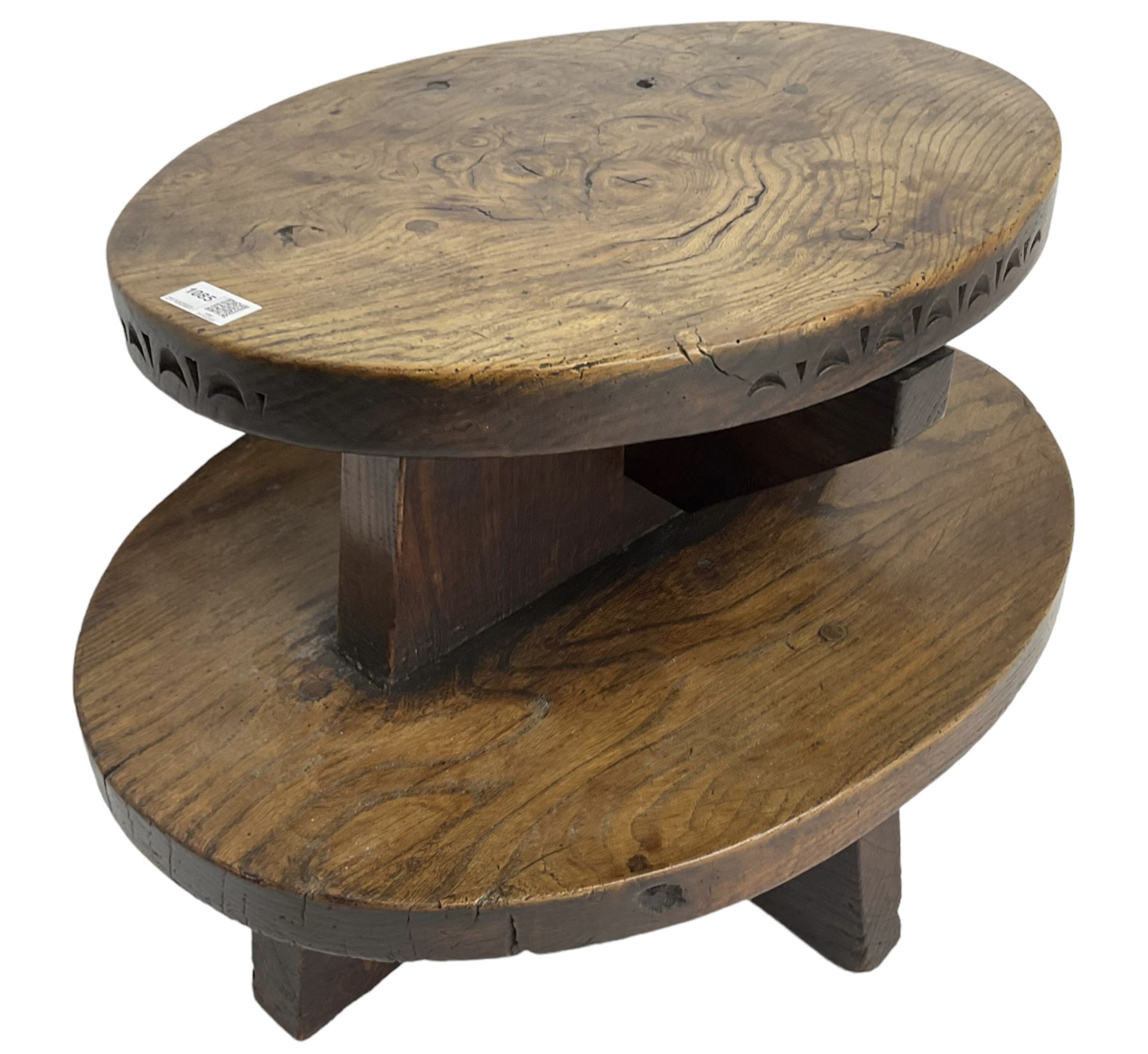 20th century figured elm occasional table, two oval tiers raised on cruciform base, the top tier carved with incised decoration 