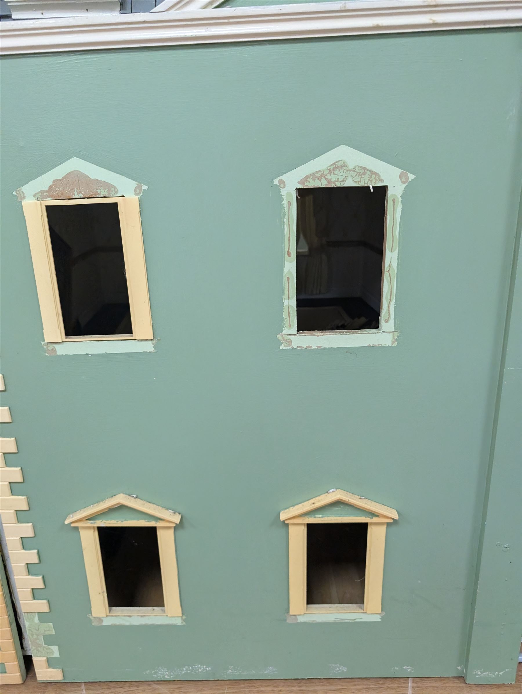 Two modern three storey dolls houses, each painted green with decorated interiors, both upon a single white wooden base, together with a large collection of dolls house furniture, accessories and figures 