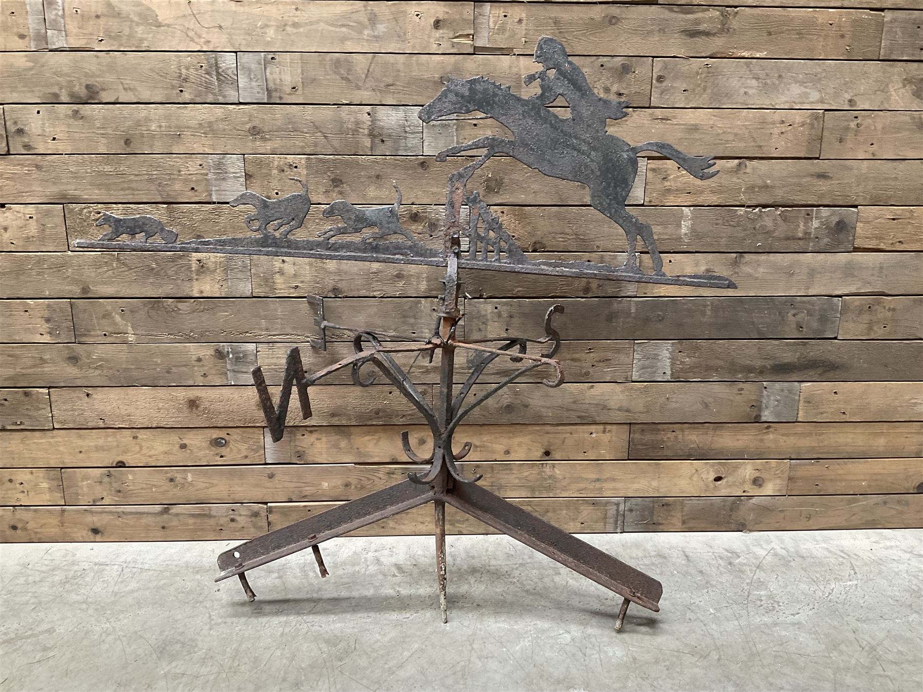 Black painted wrought iron weather-vane depicting hunting scene and compass points