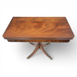 Victorian design mahogany card table, rectangular top with swivel and fold open action, revealing a baized lined interior, raised on turned baluster column, with reeded legs terminating in brass paw castors 