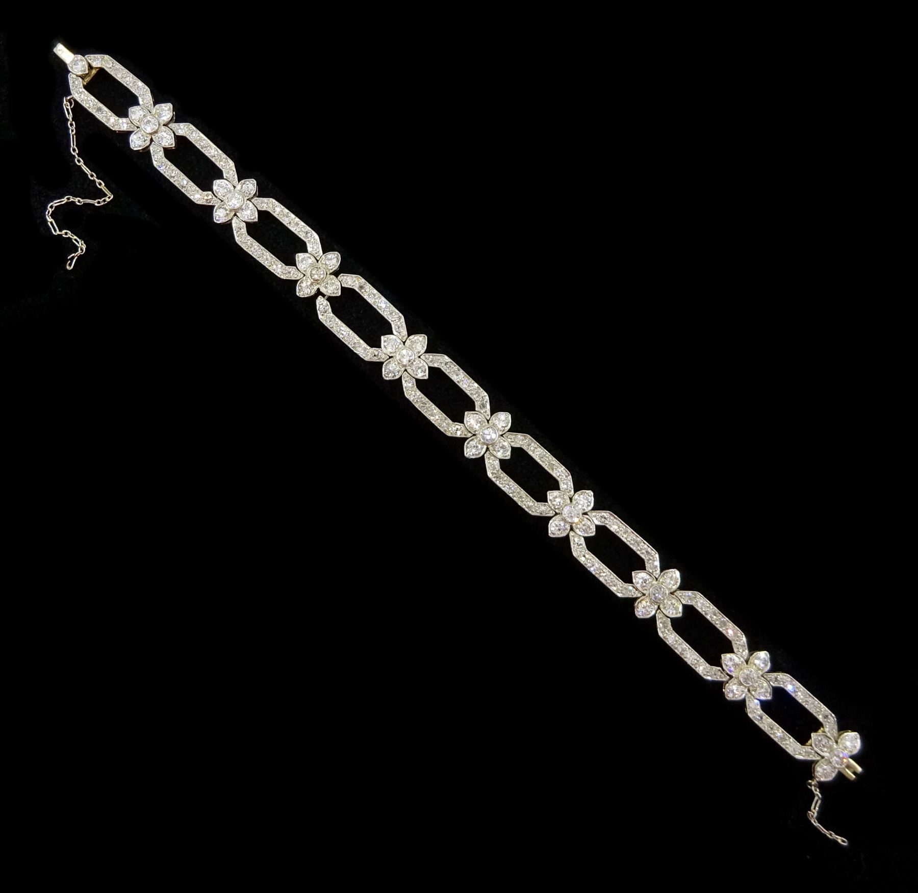 18ct white gold and platinum, milgrain set old cut diamond flower head and openwork panel link bracelet, total diamond weight approx 4.25 carat