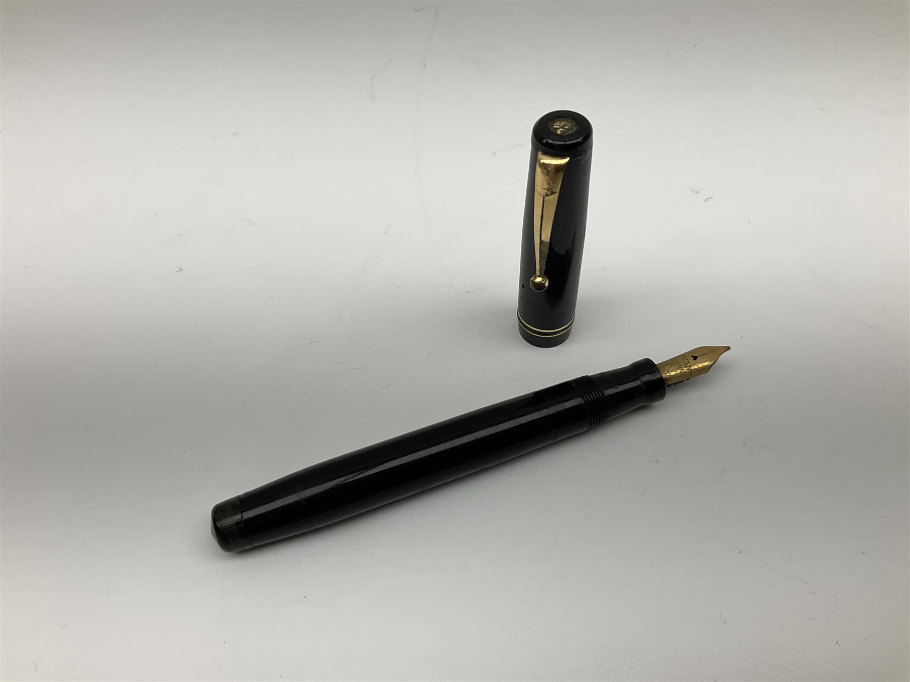 Vintage Swan Mabie Todd lever fill fountain pen in coral red, the nib a/f marked 14K, together with two further vintage Swan Mabie Todd fountain pens, the first example with lever fill, the other leverless, each with black body, one with nib marked 14ct, (3) 