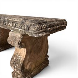 Weathered cast stone three-piece garden bench, with rectangular seat with egg-and-dart moulded edge, raised on end supports decorated with S-scrolls and fruiting vines