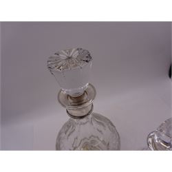 Two modern silver mounted decanters, the first example with etched and cut fruiting vine decoration to glass body, with faceted stopper, hallmarked C J Vander Ltd, Birmingham 1980, the second smaller example, with oval cut decoration and flambe type stopper, hallmarked S J Rose & Son, Birmingham 1985, tallest H28.5cm