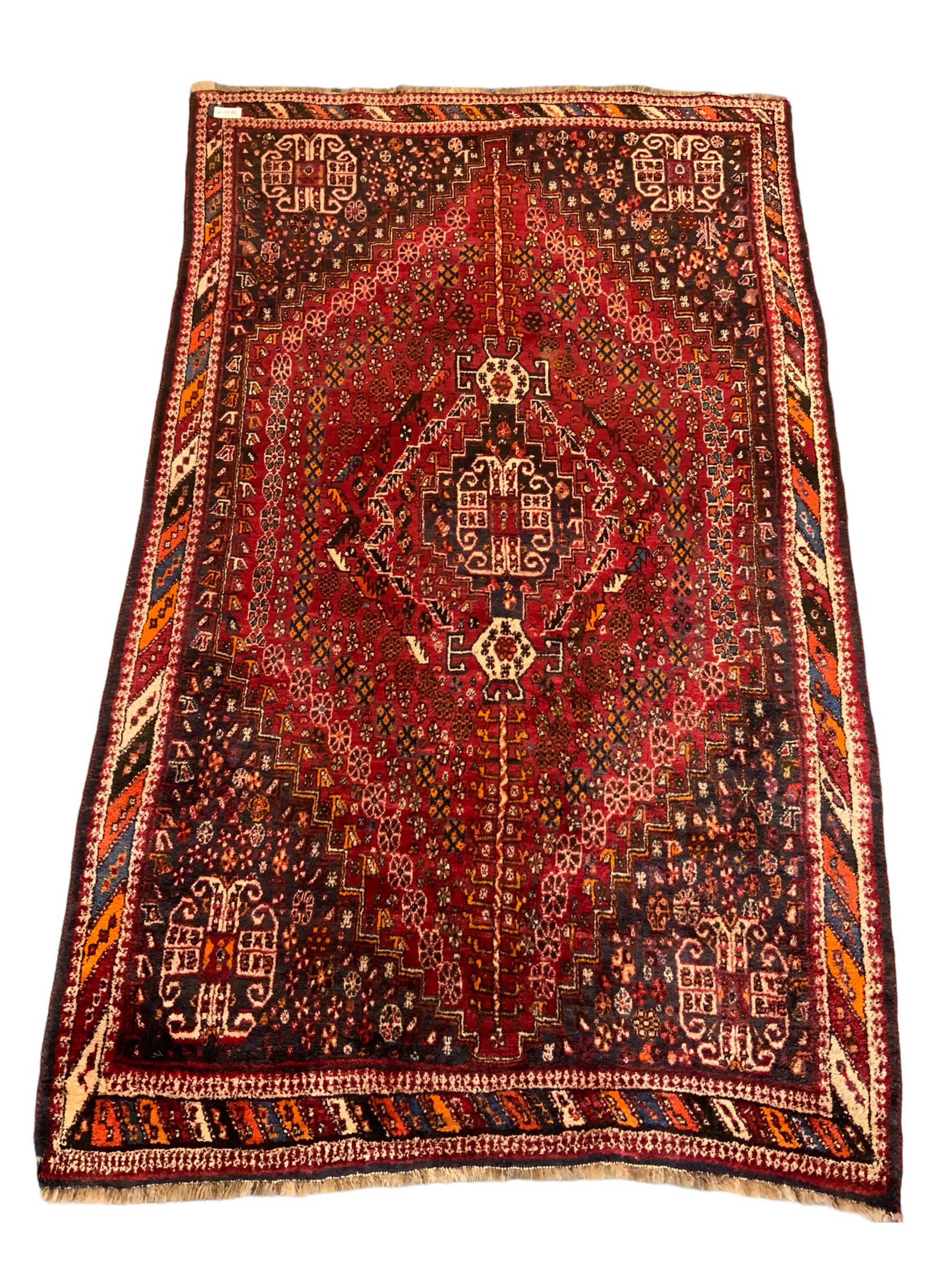 Persian red ground rug carpet, central diamond medallion, multicoloured chequered border