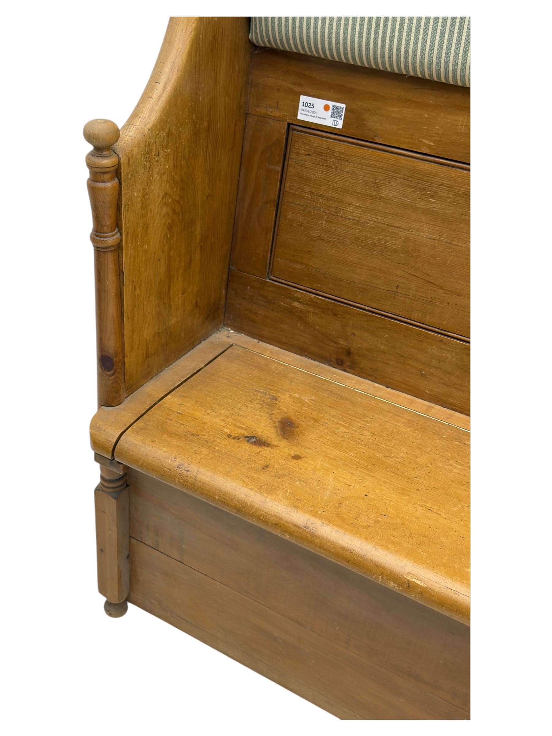 Early 20th century waxed pine pew, inset upholstered striped back panel with hinged box seat enclosing storage, shaped arms and turned supports