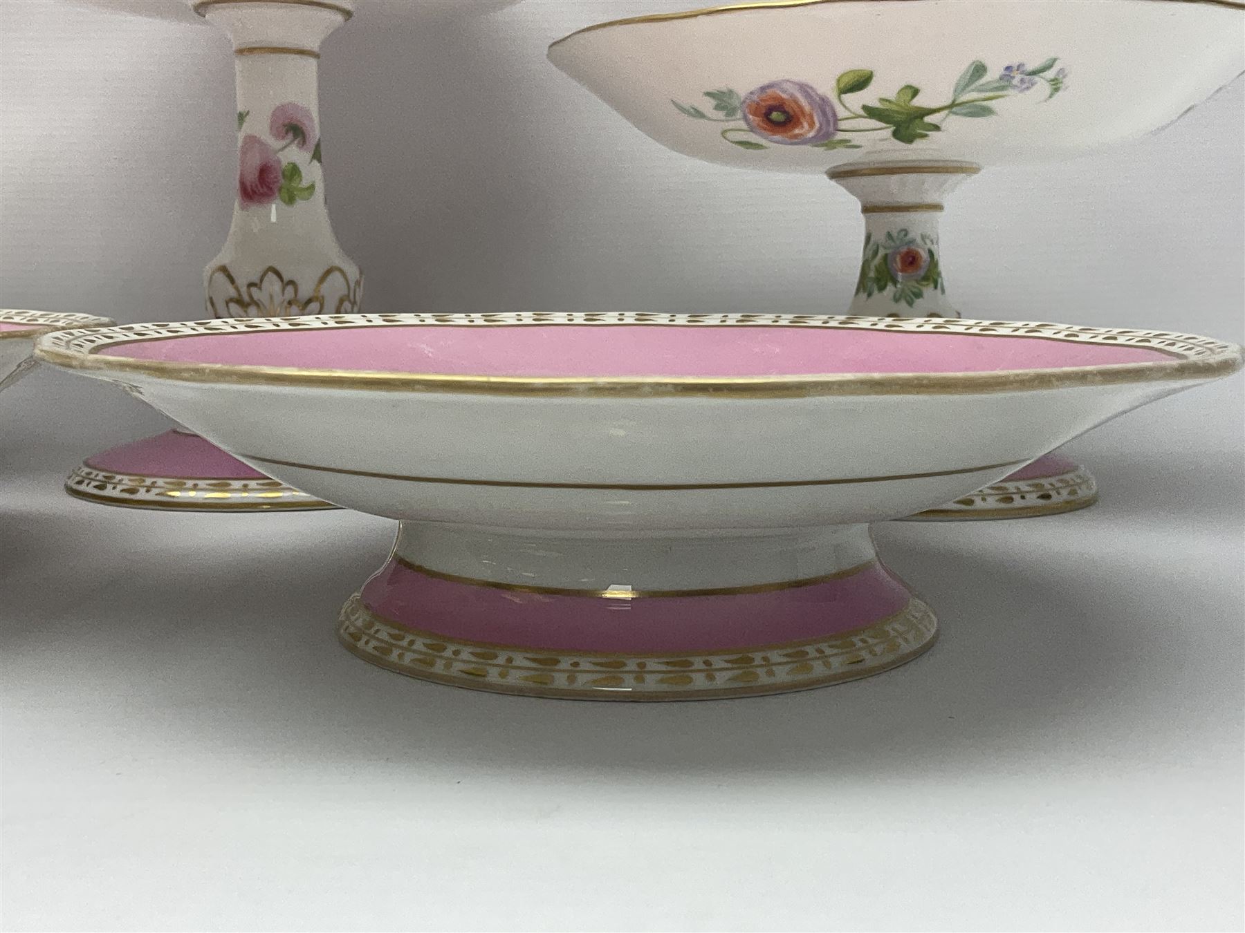 Victorian Copeland, Botanical dessert service, decorated with floral sprigs to the centre with a pink and gilt border, comprising five comports and seven plates, largest comport H20cm, plate D22cm