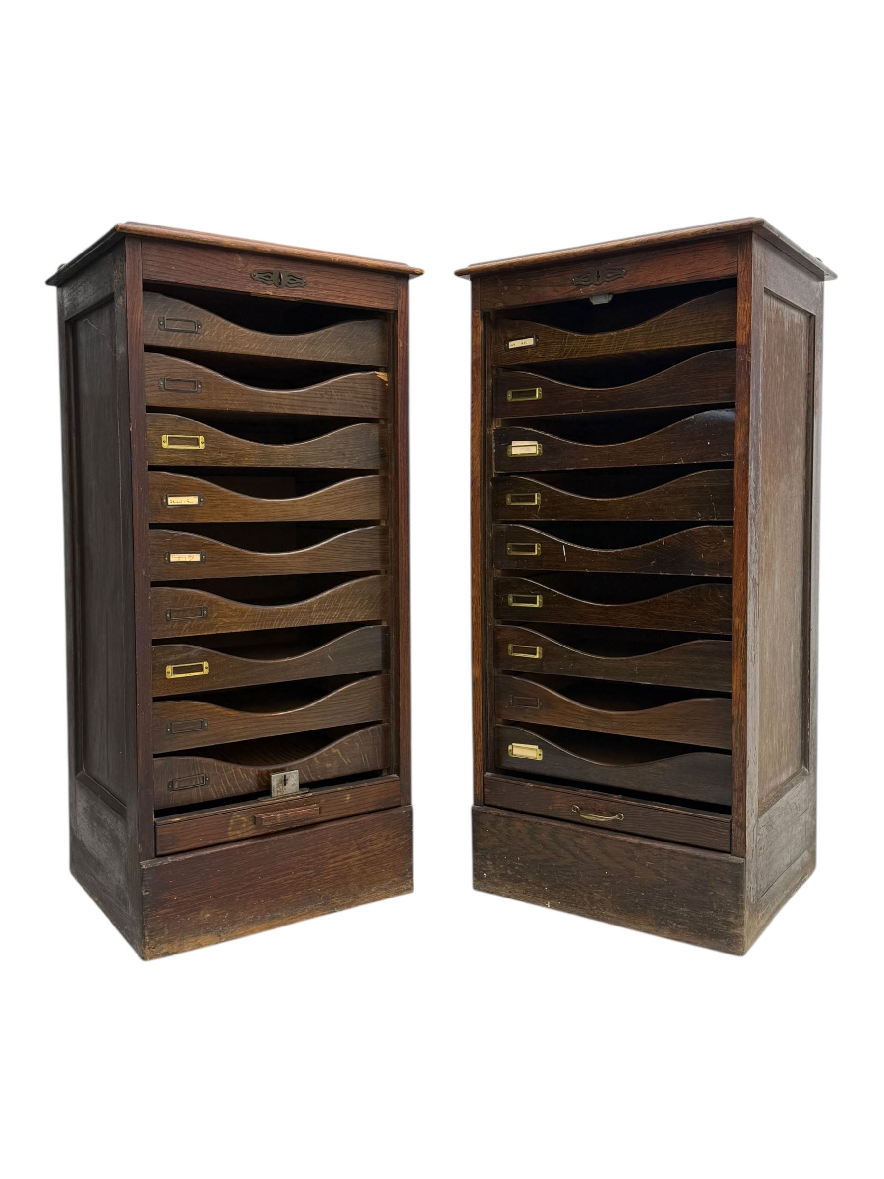 Two early 20th century mahogany tambour cabinets, each with retractable roll-top front revealing fitted interior with concave-front filing drawers and brass fittings
