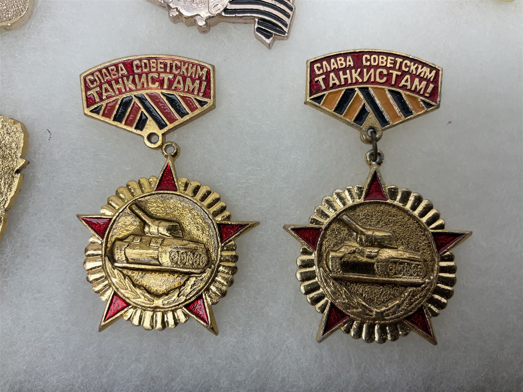 Nineteen Russian Soviet Tank Commemoration badges and medals, in small display case
