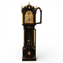Late nineteenth century ebonised and gilt-bronze mounted musical longcase clock of impressive architectural form, the case of ebonised finish with applied gilt bronze neoclassical inspired masks and mounts, hood of arched form with glazed door, flanked by free fluted columns with gilt bronze Corinthian capitals surmounted by stylized Lion finials, frieze and arch enriched with applied foliate mounts, trunk with a rectangular glazed door bordered by mouldings and flanked by engaged columns with gilt bronze mounts above a shaped projecting base panel with applied central female mask and corner foliate ornamentation, arched brass dial, with a silvered chapter ring and applied cast gilt bronze spandrels and arch decoration, incorporating subsidiary selection dials for chime/silent and tune regulation, offering Cambridge chimes on eight bells and an additional chime sequence on ten bells, brass arch is further embellished with a moon phase aperture with lunar calendar scale, Zodiac symbols, month and date indication on a silvered dial, substantial eight-day, three-train movement with pinned cylinder musical train and a graduated nest of eleven bells with eleven hammers, quarter chiming with separate hour/half-hour strike and chime repetition, movement is regulated by an anchor escapement, with brass disc pendulum, three brass weights, two winding keys and case door key
