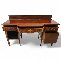 Edwardian Sheraton Revival inlaid plum pudding mahogany serpentine sideboard, rectangular top with raised gallery above bowed frieze drawer finely inlaid with central neoclassical urn motif, flanked by two drawers with swags and ribbon bows, above a cellarette drawer and cupboard, on square tapered supports with spade feet 