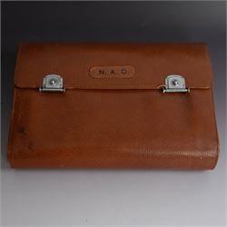 1920s gentleman's travelling case by Mappin & Webb Ltd, tan leather impressed with initials NAO, opening to reveal a compartmentalised interior containing silver mounted dressing table items, including a pair of silver mounted brushes, engraved NAO AMA 1918, hallmarked William Comyns, London 1911, five faceted glass jars and bottles with silver lids and a silver shaving brush holder, all hallmarked Mappin & Webb Ltd, London 1922, tan leather box containing razor, silver plated shoe horn, scissors and bevelled edge shaving mirror with easel support