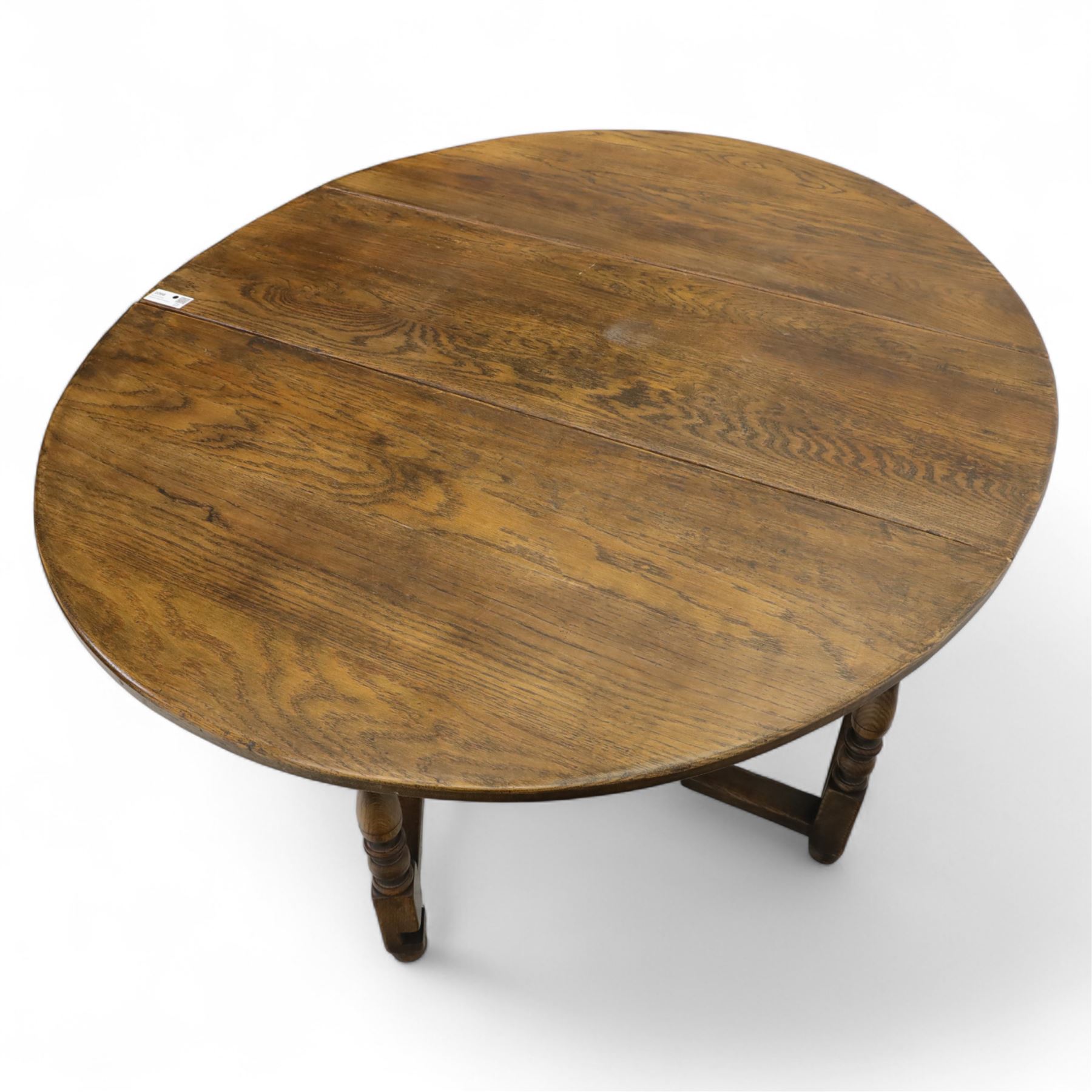 17th century design oak gateleg dining table, oval drop-leaf top on baluster turned supports, twin swinging gate legs united by peripheral stretchers (Extends to 149cm)