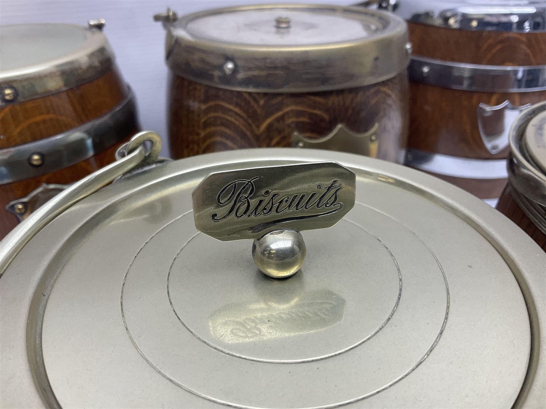Five early 20th century biscuit barrels with silver-plated mounts