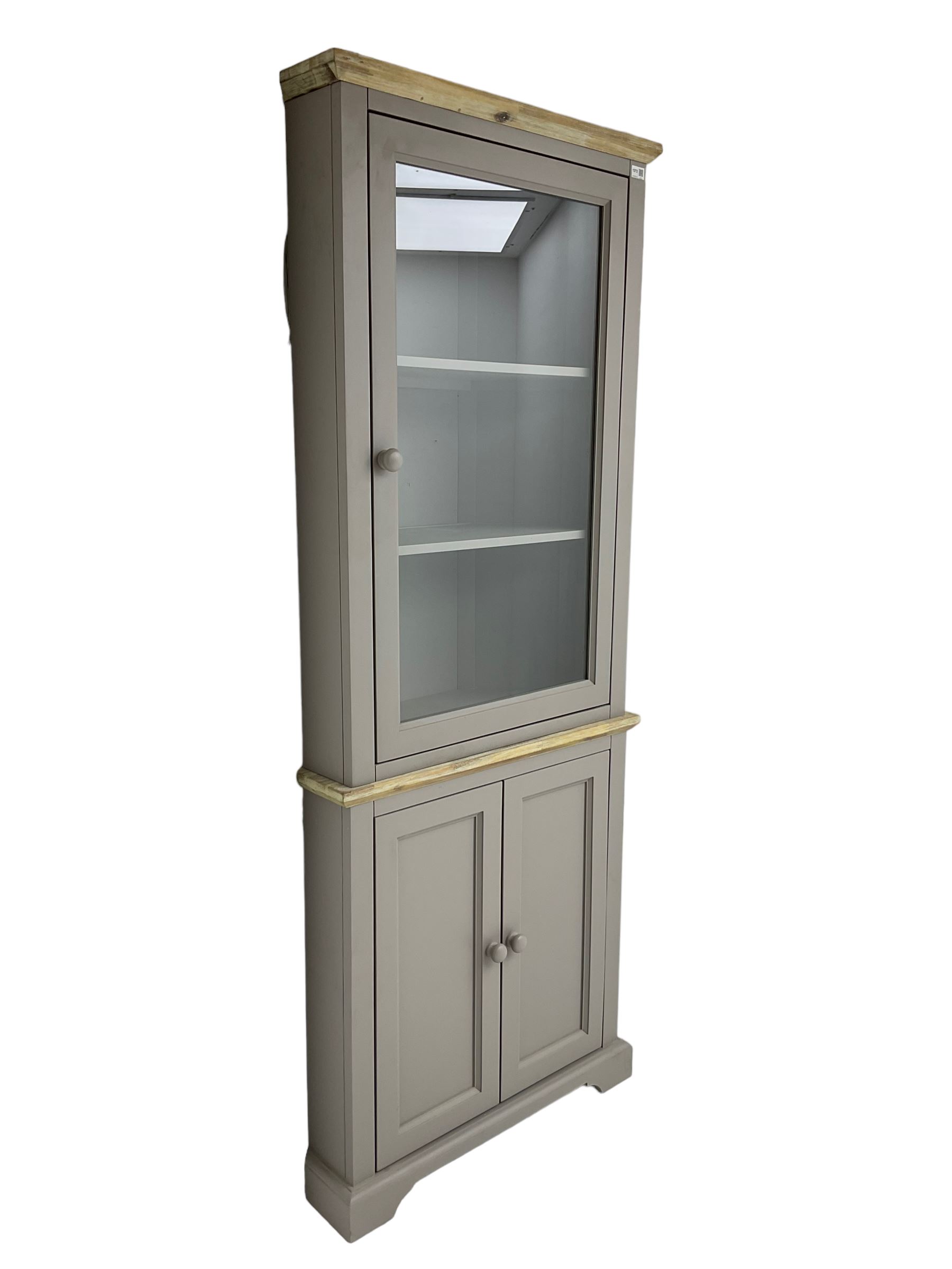 Contemporary teal and oak finish corner cabinet, single glazed door enclosing two shelves, over two panelled cupboard doors