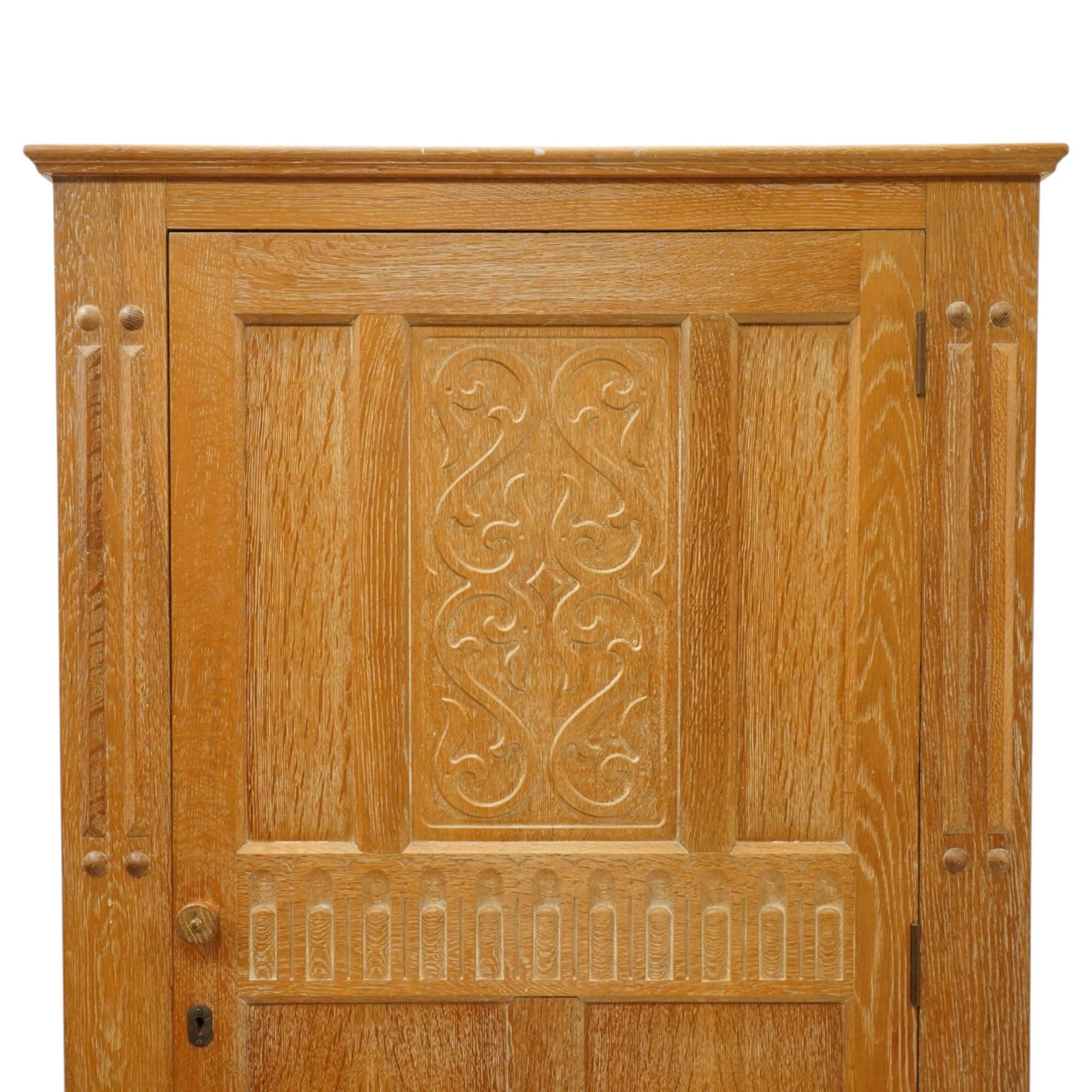 Arts & Crafts design limed oak bedroom suite; comprising dressing table, single wardrobe and chest, with carved scrolling motifs.

Wardrobe (H 181cm, D 47cm, W 79cm)
Chest (H 74cm, D 46cm, W 73cm)
Dressing table (H 136cm, D 47cm, W 74cm)