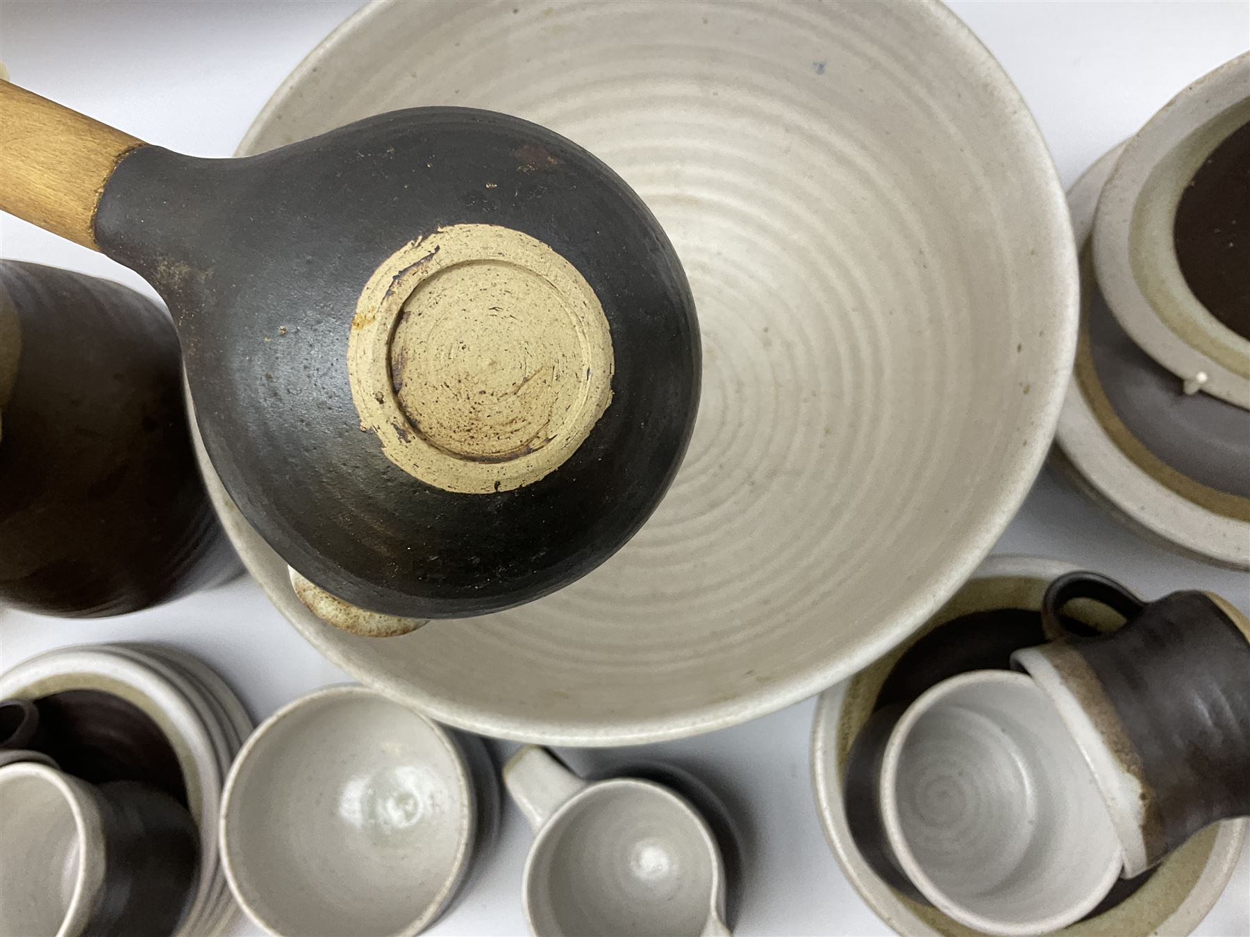 Marianne De Trey (British 1913-2016) stoneware coffee service for twelve, together with a large deep stoneware footed bowl and ladle with wood handle, all decorated in Manganese 'Pattern 1' with impressed shell marks, bowl D27cm