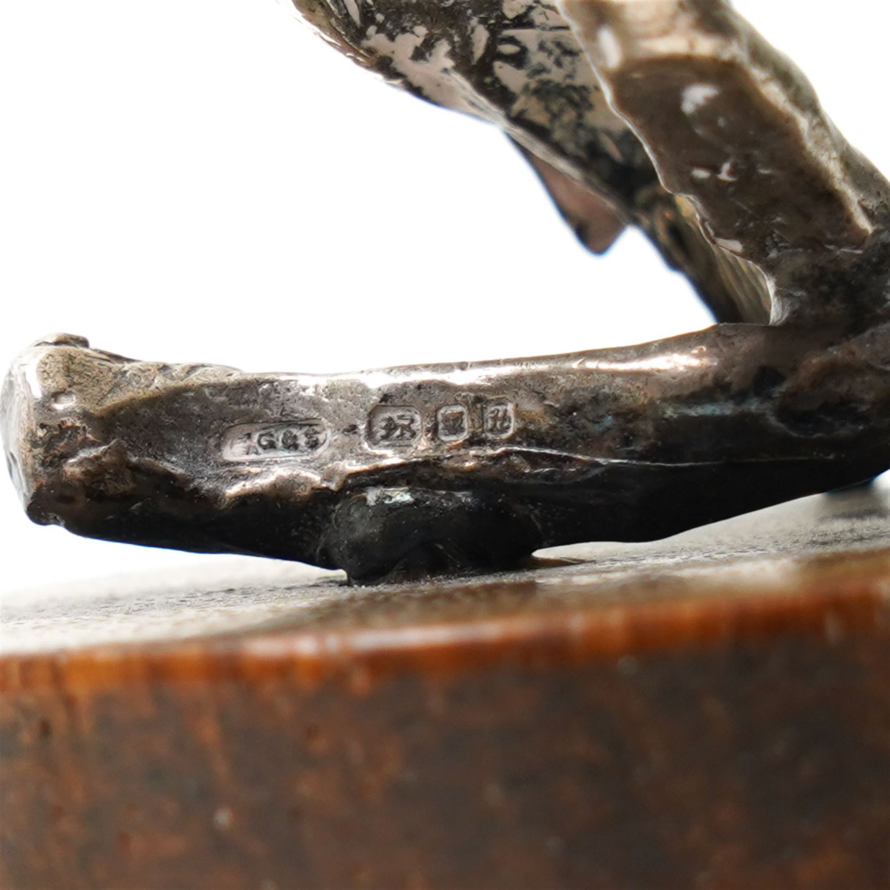 Silver model of a bird perched on a branch and with wooden base by Goldsmiths and Silversmiths Co. H5cm, small silver model of a pheasant on wooden base H2.5cm and a silver miniature model of a dog in a basket marked 925 and indistinct maker's mark L3.5cm (3)