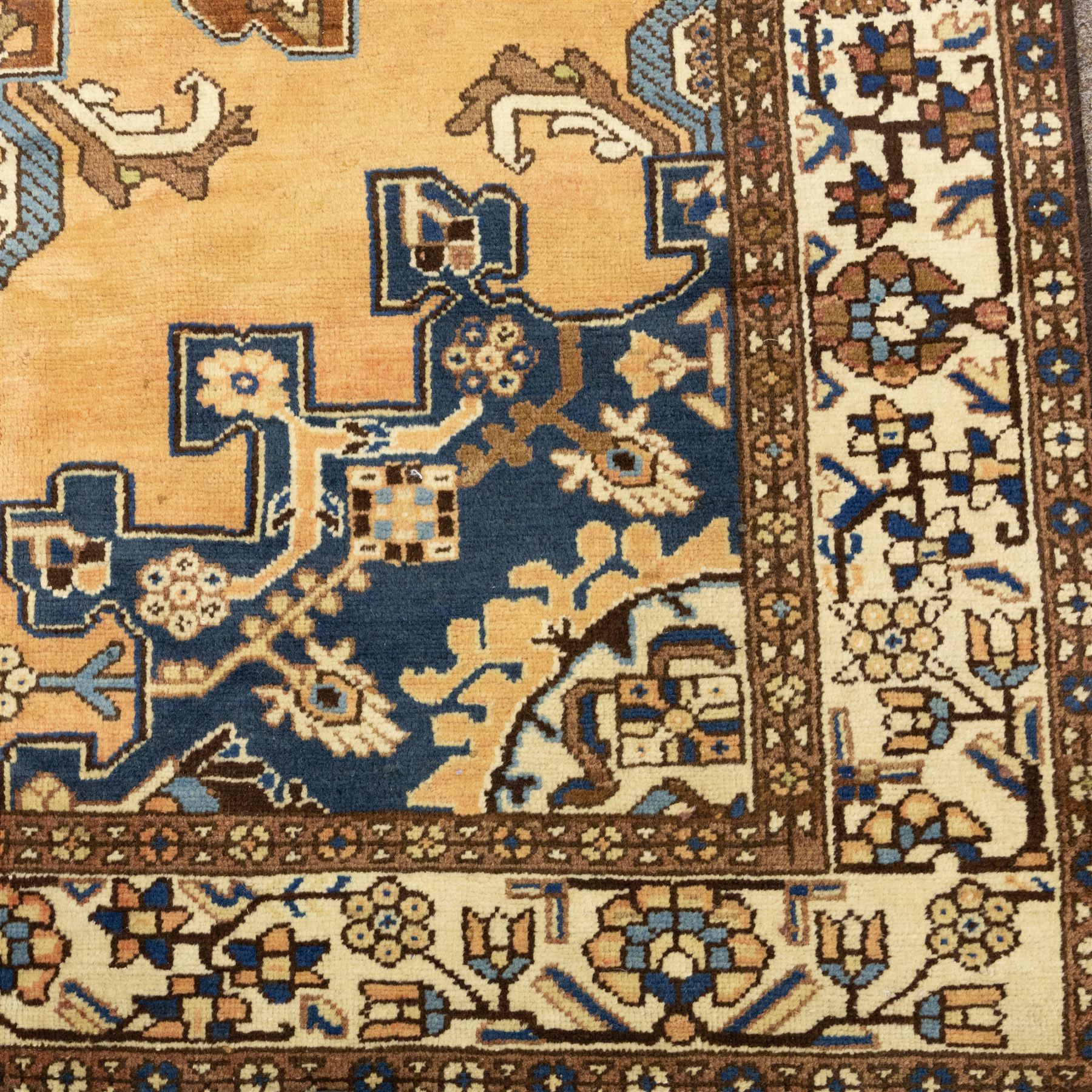 North West Persian Tafresh hand-knotted rug, pale apricot field with central stepped medallion enclosing stylized floral and angular motifs framed by indigo spandrels and multiple stylized floral borders, cotton fringe ends 