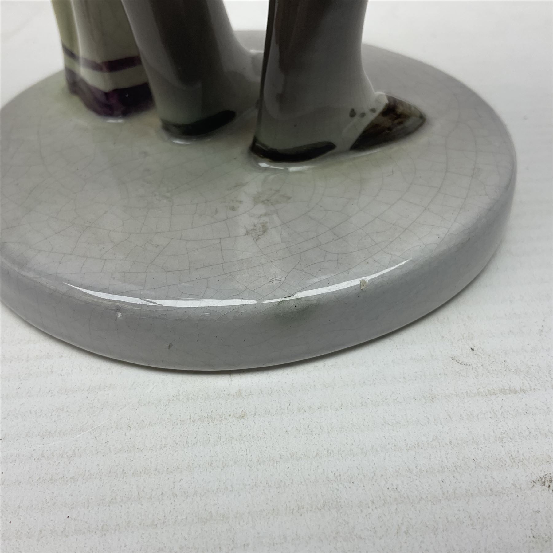 Goldscheider figure, modeled as a gentleman with flowers, upon a circular base, with printed mark beneath, H25cm