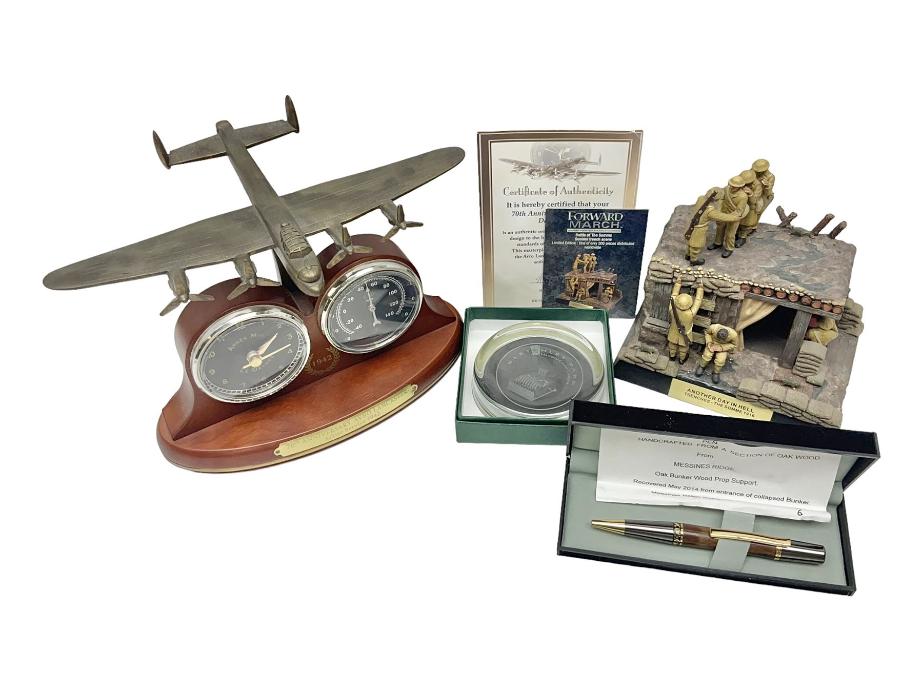 Bradford Exchange 70th Anniversary Lancaster Desk Clock/Barometer; wing span 24cm; with certificate; Corgi Forward March Somme Trench Scene 'Another Day in Hell'; limited edition of 500 with certificate; cased pen handcrafted from a section of oak wood from Messines Ridge (bunker wood prop support); limited edition No.1/6 with certificate; and boxed Bletchley Park souvenir paperweight (4)