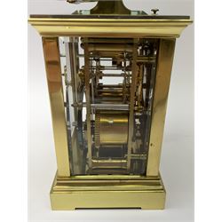 Early 20th century brass and bevelled glass repeater carriage clock with alarm, the angular and cylindrical ribbed handle and repeater button over stepped cavetto cornice, white enamel Roman dial with Arabic subsidiary alarm set dial, twin train eight day movement striking the hours and half on coil, separate alarm mechanism train, stepped moulded and plain faced base, with leather travelling case