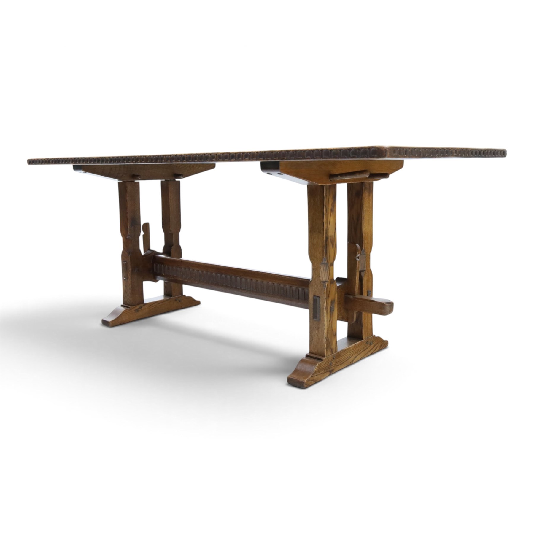 Rupert Griffiths for Monastic Woodcraft - oak 6ft refectory dining table with set six (4+2) matching chairs, rectangular top with arcaded frieze, with trestle base with further arcaded carved stretchers, chairs with carved rails and finials, leather wrapped seats with stud detail, turned supports united by carved stretcher