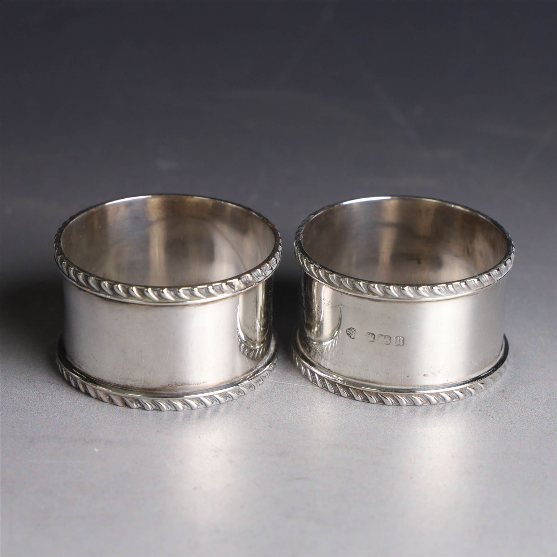 Pair of early 20th century silver napkin rings, plain circular form with oblique gadrooned rim, no engravings, hallmarked William Hutton & Sons Ltd, Sheffield 1912