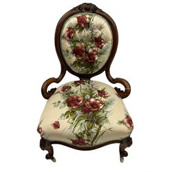 Victorian walnut framed nursing chair, the cameo open back with cartouche carved cresting rail, upholstered in buttoned rose pattern fabric, carved cabriole supports
