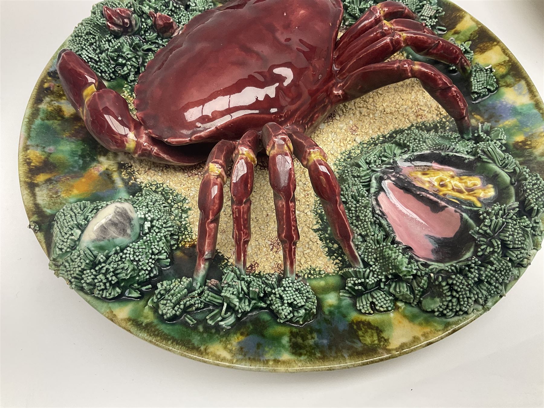 Two 20th Century Portuguese Palissy style Majolica wall plates, one depicting a crab, the other a lobster each to the centre modelled in relief surrounded by encrustations and shells, both with impress marks beneath, D34cm