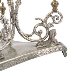Silver plated Egyptian Revival lamp, with scrolling columns, on a trefoil base, surmounted by three sphinxes, with mask feet, H60cm