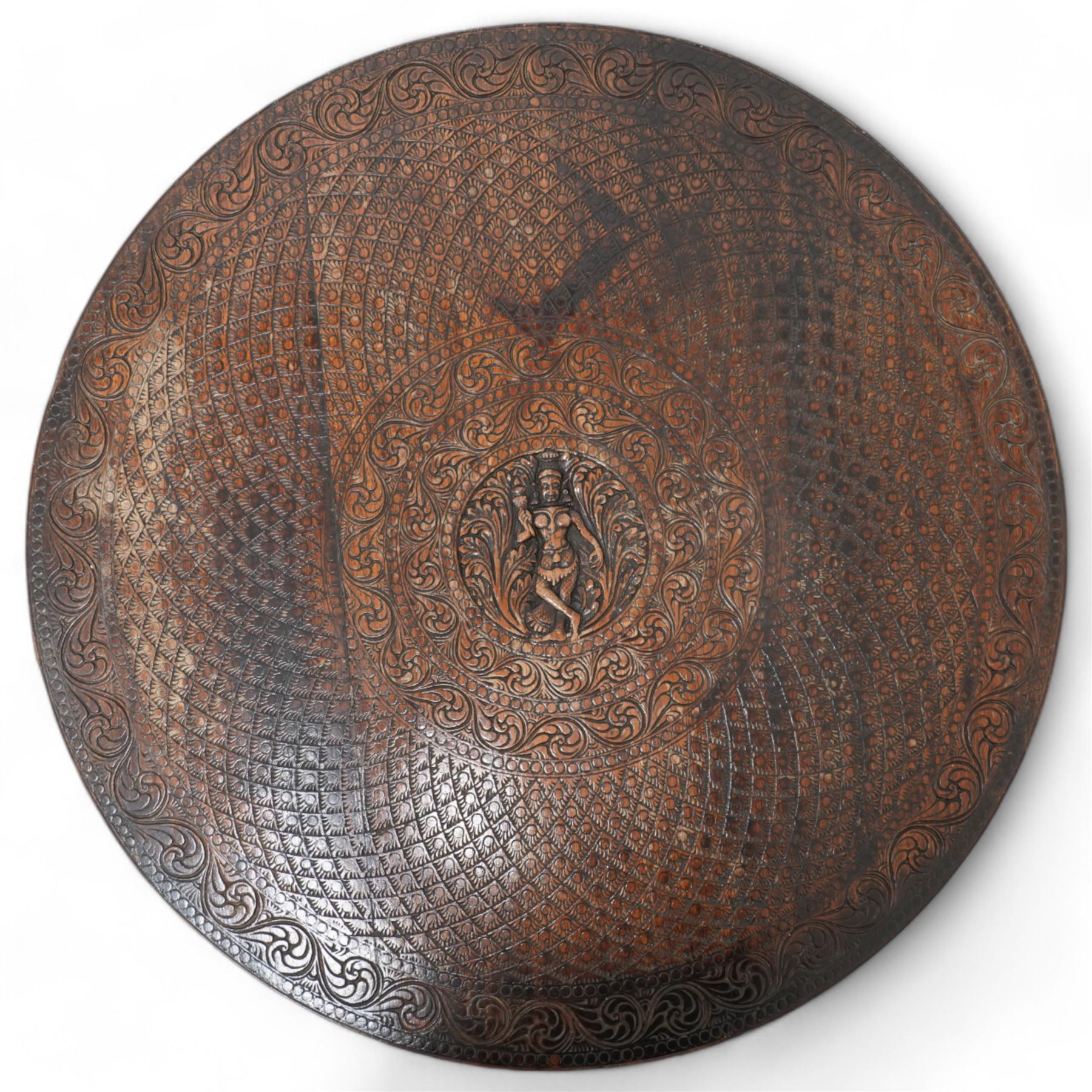 Anglo-Indian hardwood occasional table, circular top carved with concentric pattern and scrolling foliage, on three elephant carved supports decorated with flower heads