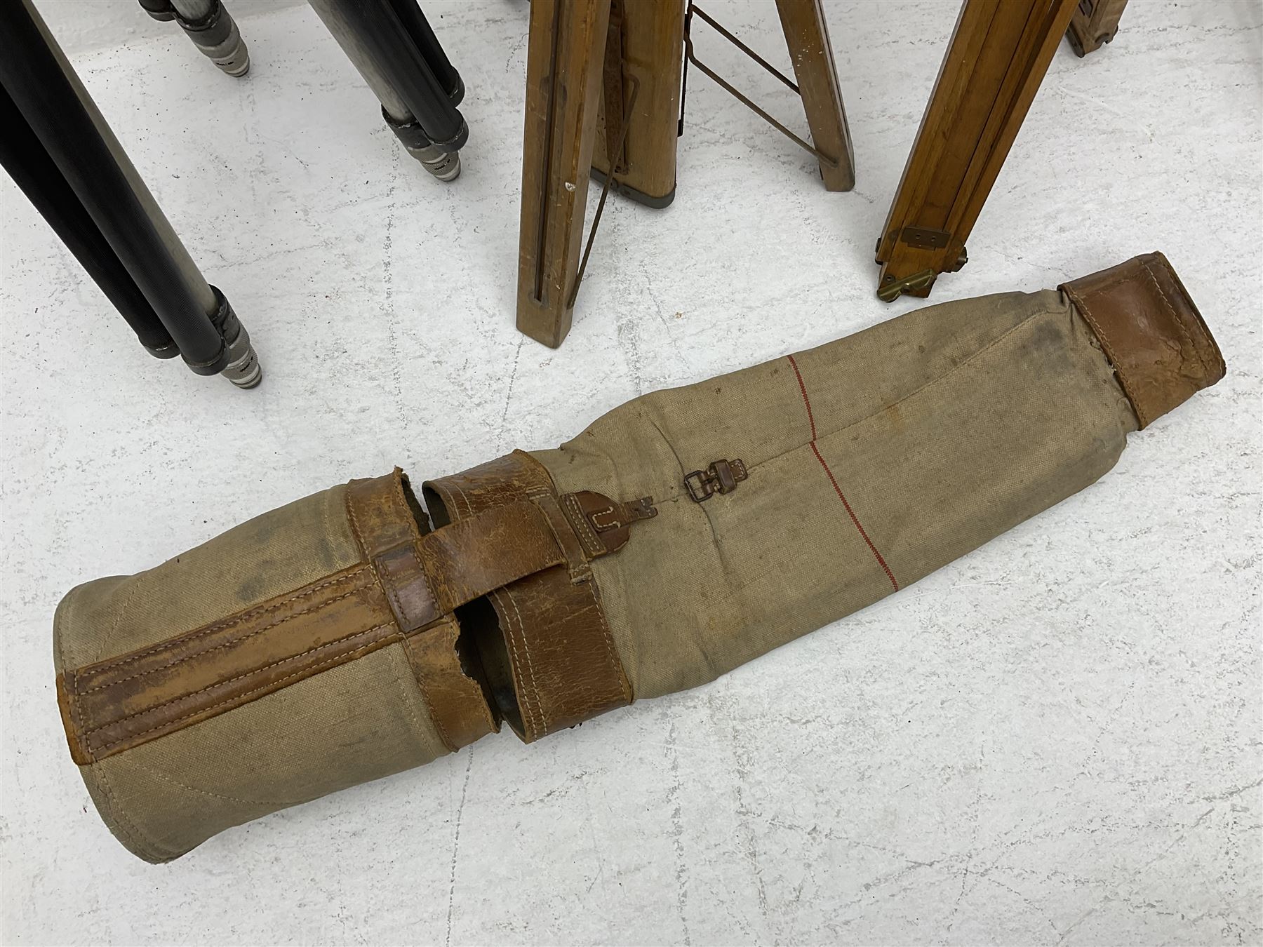 Three wooden adjustable tripods for plate cameras, together with a Linhof of Munchen metal tripod in a canvas case 